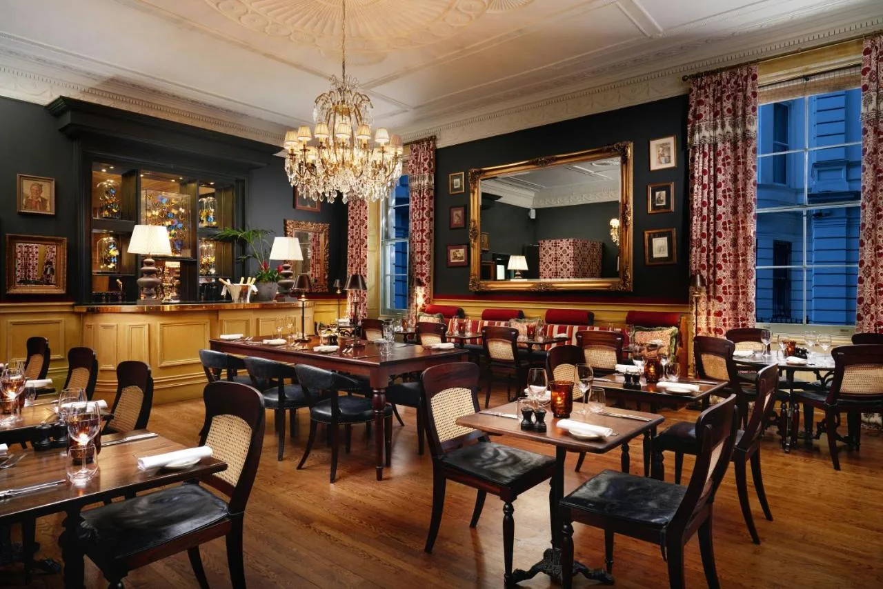 Restaurant with wooden tables and chandelier at The Gore London